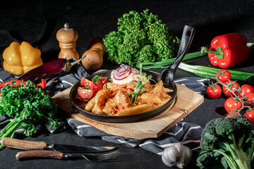 Wall Mural - Roasted potato with cabbage stewed on frying pan in dark background