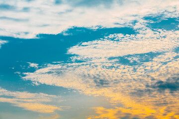 Wall Mural - Dramatic sky of golden or yellow sunset light with blue sky and white clouds at evening time with small birds fly.