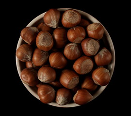 Wall Mural - Hazelnuts in bowl isolated on black, top view 
