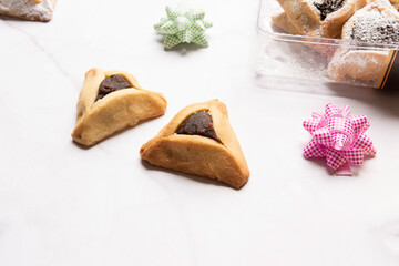 Purim celebration concept, jewish carnival holiday. Traditional hamantaschen cookies over white wooden table. High quality photo