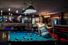 Beautiful Young Woman Is Sitting On The Snooker Table