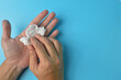 © TeacherPhoto - Hands wiping using white paper tissue isolated on a blue background. Healthcare, hygiene and safety concept.