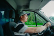 © velimir - a male truck driver is driving, a young european man.