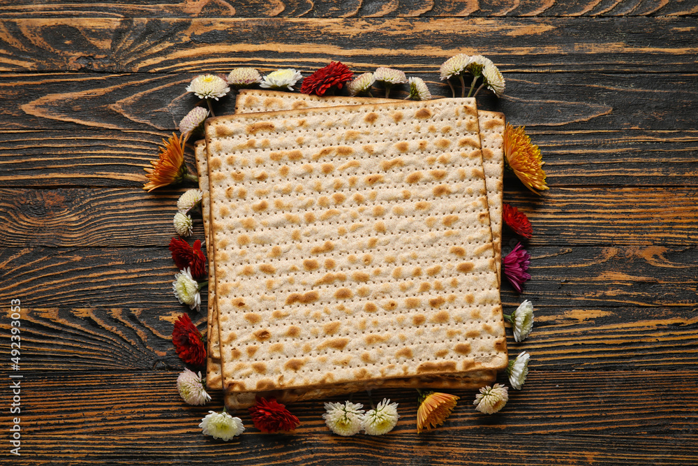 Jewish flatbread with flowers on wooden background