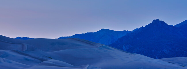 Panoramic image of large sand dunes at sunset and dusk on Colorado