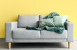 © Pixel-Shot - Stylish sofa near yellow wall