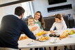 © BGStock72 - Young happy family talking while having breakfast at dining table