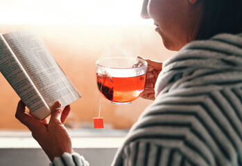 Poster - Reading books isnt a hobby, its a passion. Cropped shot of an unrecognizable young woman reading a book while drinking a cup of tea at home.