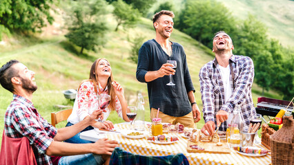 Wall Mural - Happy friends group having fun drinking red wine at barbeque pic nic garden party - Young people eating tasty meal at farm house restaurant - Food and beverage life style concept on bright warm filter