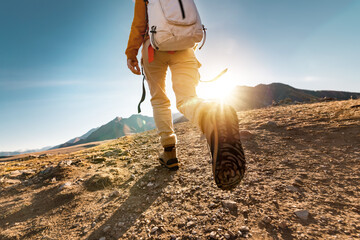 female hiker walks in mountains. close up photo of legs