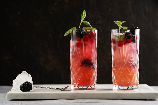 two long glasses with non-alcoholic mocktail version of the classic blackberry and gin cocktail bram