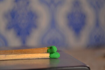 two matches with a green sulfur head close-up.