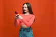 Modern teen girl holding smart phone using mobile applications, chatting in social media, shopping, playing online games