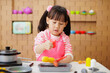 young girl pretend playing food preparing at home