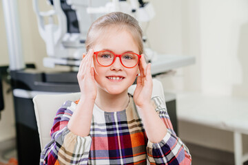 a pretty little girl in colored-rimmed glasses. glasses for children. 