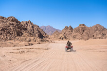 Mountains Landscape And Person On Motorbike. Quadricycle Safari Park In Egypt Sand Desert. Sharm El Sheikh, Sinai Peninsula. Extreme Travel On All-terrain Vehicle.