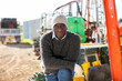 Portrait of adult African-american man worker standing outdoors.