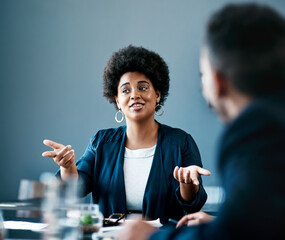 Wall Mural - Any thoughts. Cropped shot of an attractive young businesswoman talking to her colleagues during a meeting in the boardroom.