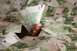 hand with euro banknotes climbs out of a mountain of money