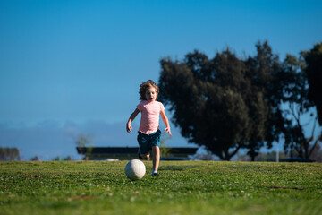 Soccer kids, child boy play football outdoor. Young boy with soccer ball doing kick. Football soccer players in motion. Cute boy in sport action. Kids training soccer.