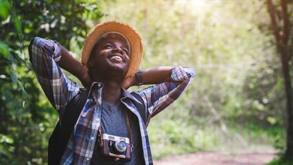 Wall Mural - African male tourist travel in wild trip hiking during vacation with holding a film camera,Adventure travel concept