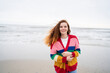 © Westend61 - Cheerful redhead woman enjoying at beach