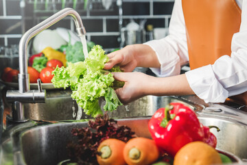 Hand of maid washing tomato fresh vegetables preparation healthy food in kitchen