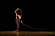 © Westend61 - Woman practicing cobra pose against black background