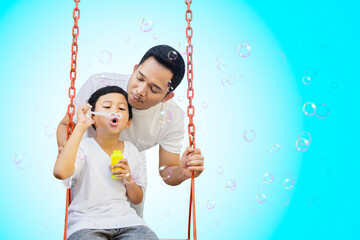 Wall Mural - Child blowing soap bubbles with father on studio