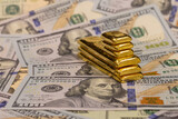 Fototapeta Londyn - pile of long and short pure gold bars, bullion, ingot on background of US dollar banknotes
