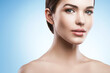© blackday - Young woman with natural makeup and smooth skin against light blue background