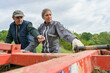 © goodluz - Couple of farmers working with tractor in agricultural field
