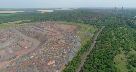 Wall Mural - Waste rock dumps in open-pit mining. Technological process of metallurgy. Aerial view of the ore mining process. Shooting on a bright sunny day.