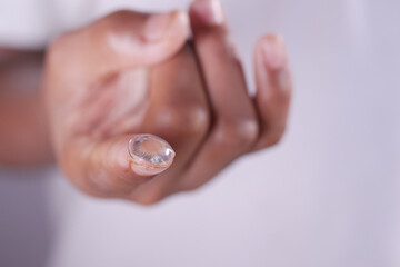 close up of Contact lens on a finger .