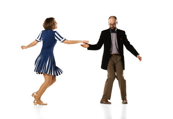 Wall Mural - Social dancing. Couple of dancers, young man and woman in vintage retro style outfits dancing swing dance isolated on white background. Timeless traditions