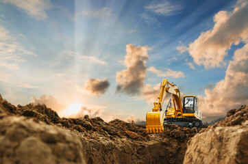 Wall Mural - Excavator with Bucket lift up are digging  soil in the construction site on the blue sky and sunset  background