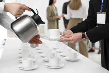 Wall Mural - Waitress pouring hot drink during coffee break, closeup