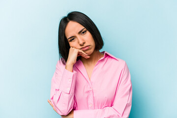 Young hispanic woman isolated on blue background tired of a repetitive task.