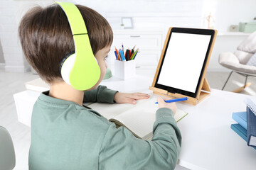 Canvas Print - Cute little boy with modern tablet studying online at home. E-learning