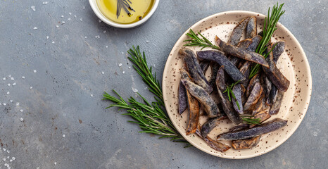 Sweet purple Potato Fries on dark background. Food recipe background. Delicious breakfast or snack, Clean eating, dieting, vegan food concept. top view