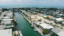 Aerial Flight Over The City Of St. Petersburg, Florida. Canals Connecting Houses And Boats Are Parked Near City Buildings. Local Infrastructure Of American Cities In Florida.