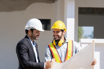 Wall Mural - Engineer with business manager are talking in construction site,Project owner with blueprint working to new residential home building work site.