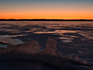 Wall Mural - lake in ice in spring against the backdrop of a red sunset