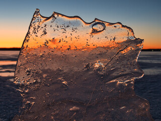 Wall Mural - lake in ice in spring against the backdrop of a red sunset