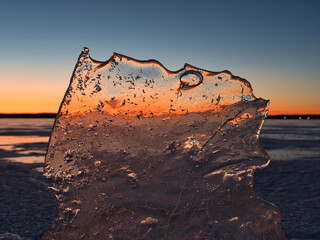 Wall Mural - lake in ice in spring against the backdrop of a red sunset