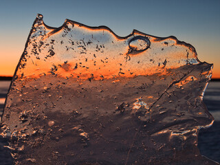 Wall Mural - lake in ice in spring against the backdrop of a red sunset
