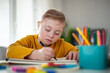 © Halfpoint - Little girl with Down syndrome drawing at home.