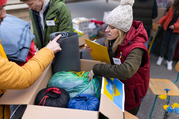 Wall Mural - Volunteers distributing blankets and other donations to refugees on the Ukrainian border.