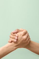 Women holding hands together on color background