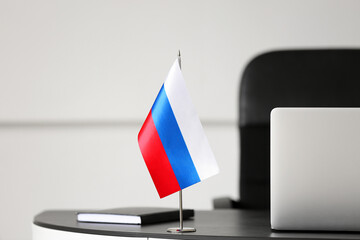 Wall Mural - Russian flag and book on dark table in light room